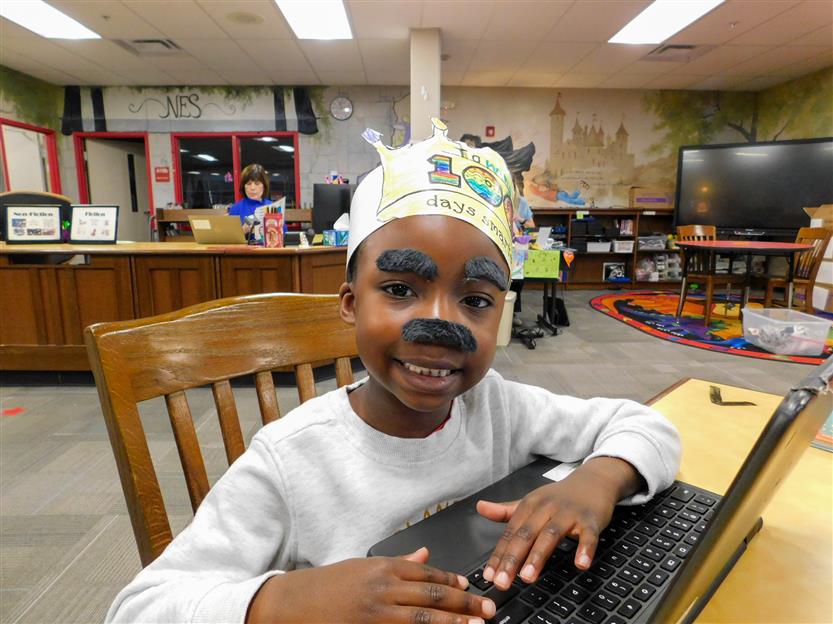 boy with gray eyebrows and mustache on his computer